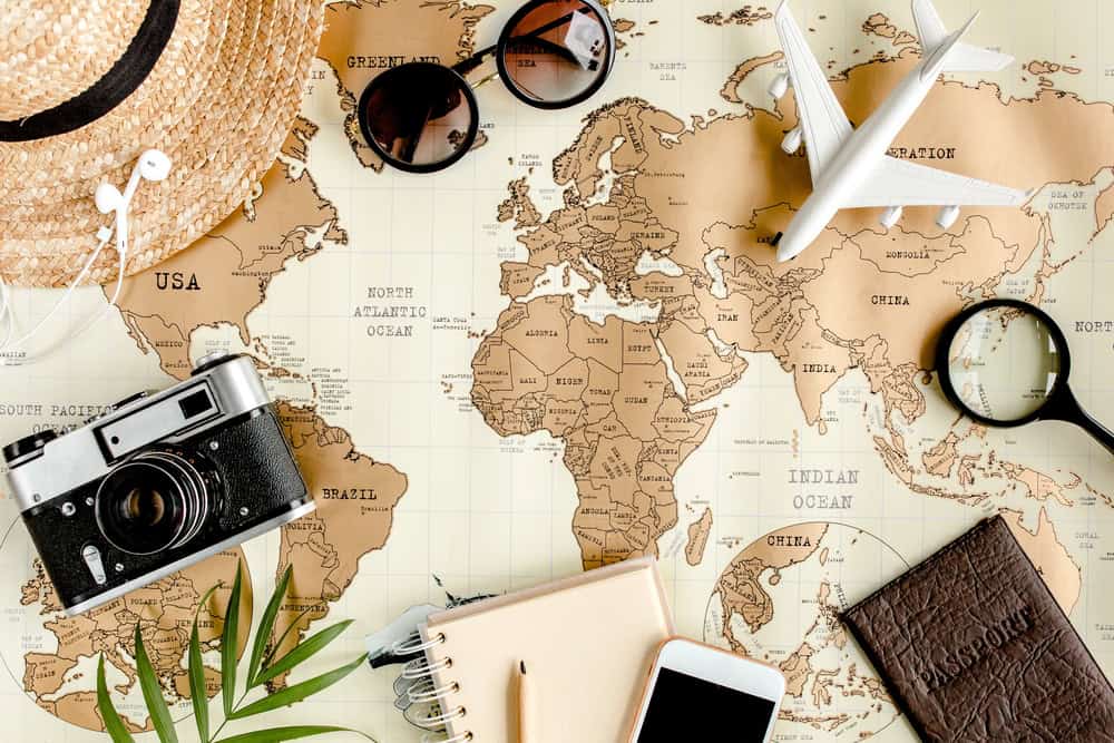 Karte mit Kamera, Sonnenbrille und weiteres Reiseuntensilien.
